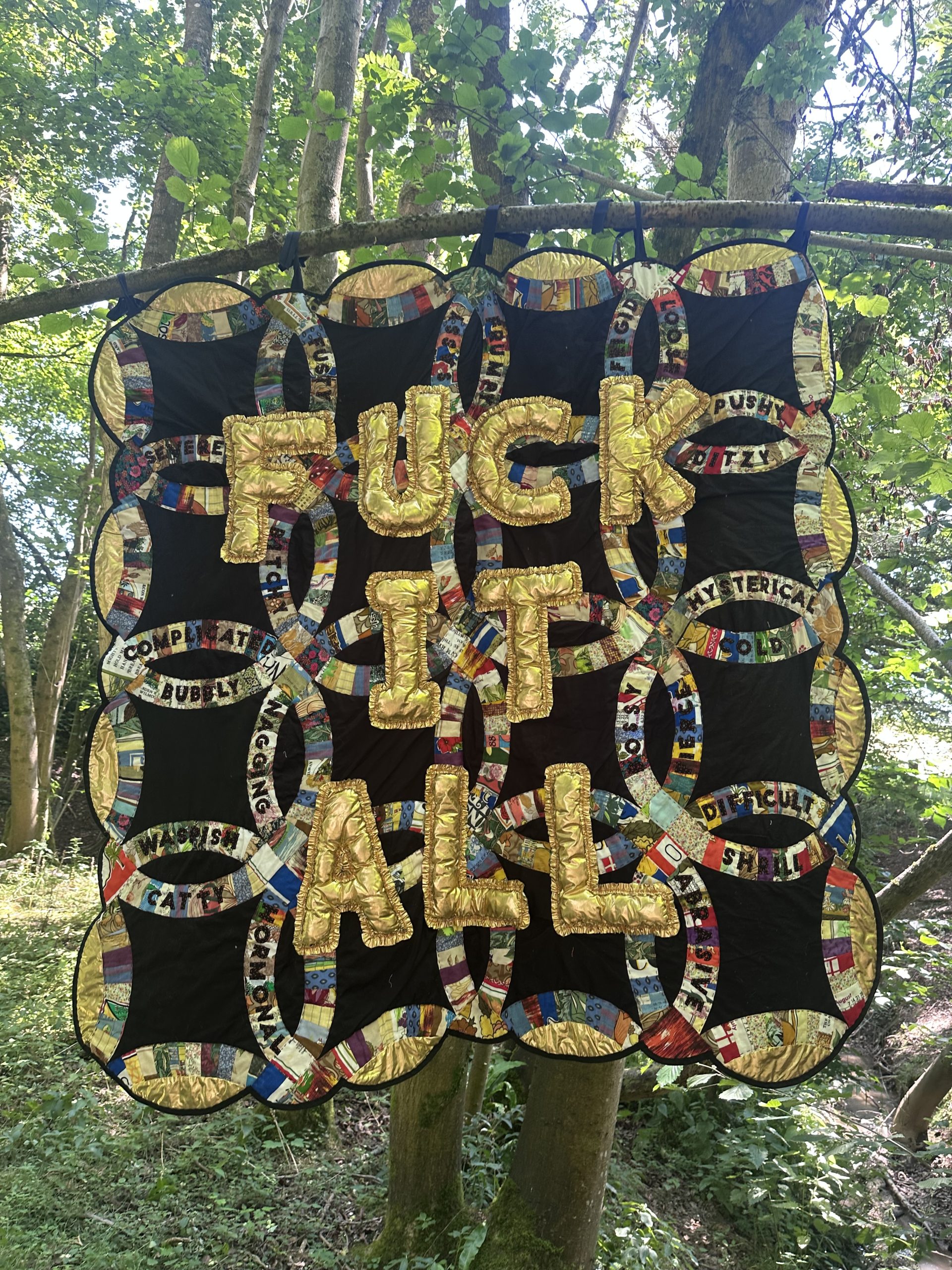 patch work with FUCK IT ALL on it in gold